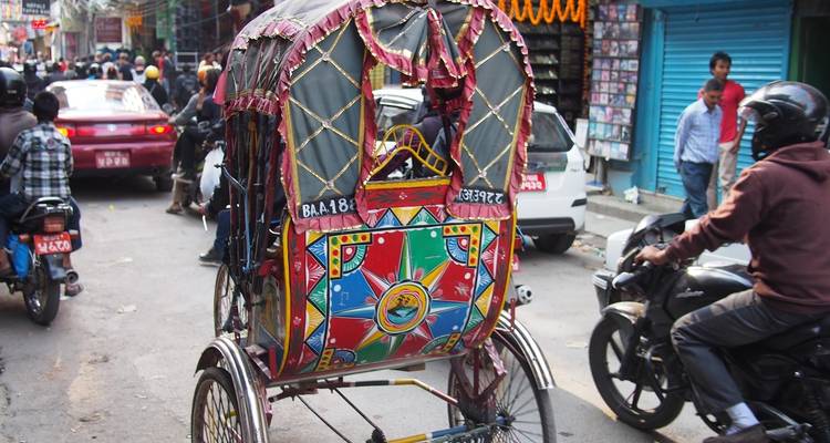 Traditionelle Rikscha in einer belebten Straßenszene.