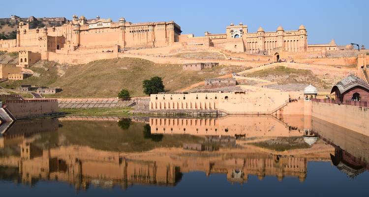 Een fort met reflectie in het water bij Jaipur.