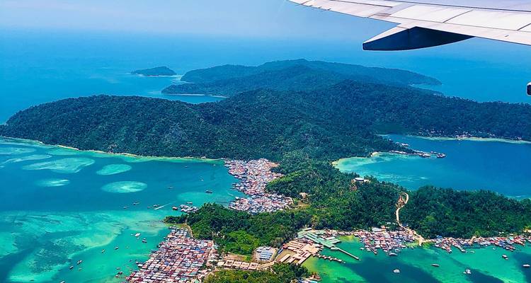Vue aérienne d'îles tropicales et du littoral avec une végétation luxuriante et une eau bleue cristalline.