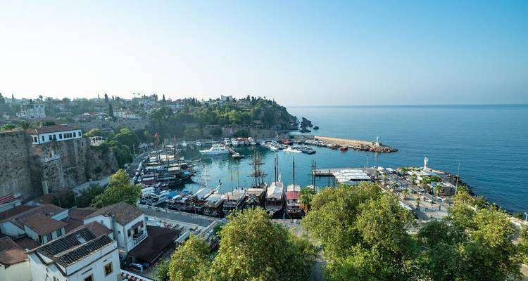 Une vue panoramique du port d'Antalya, parsemé de bateaux sur un fond de ciel bleu clair et de mer.