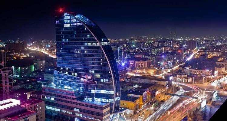 Paysage urbain moderne avec des bâtiments illuminés la nuit.