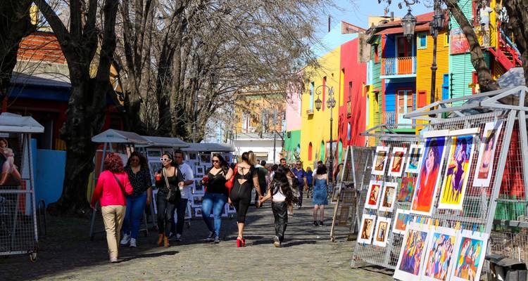 Marché de rue coloré avec plusieurs personnes qui se promènent et regardent l'art.