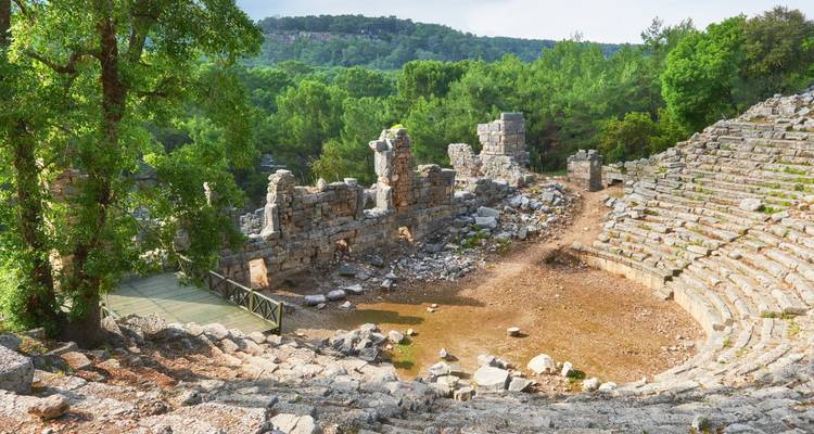 Ruines d'un amphithéâtre antique entouré de verdure en Turquie.