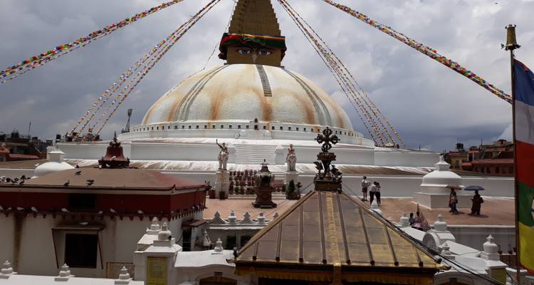Le grand dôme blanc du Stupa de Boudhanath avec des drapeaux de prière vibrants drapés du pinacle doré.