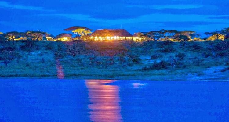 Cabaña iluminada de noche cerca del agua