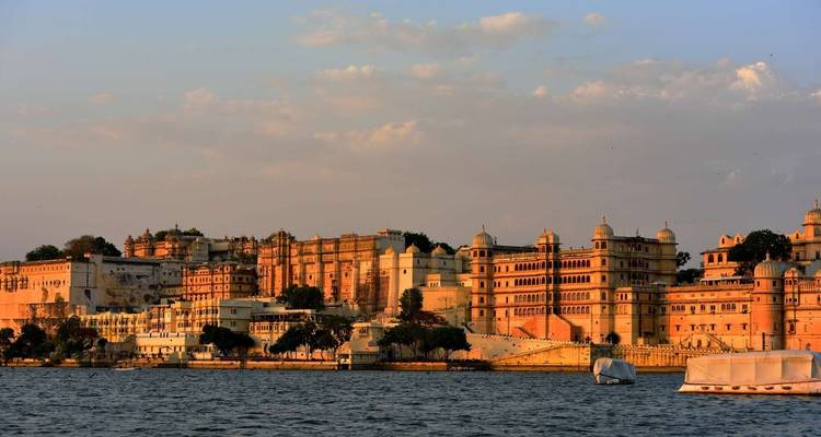 Stadsgezicht van Udaipur langs een meer tijdens zonsondergang.