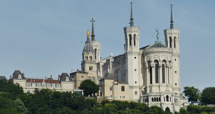 Hilltop Basilica of Notre-Dame de Fourvière with twin towers and golden statue overlooking the city.