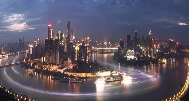 Vista panorámica nocturna del horizonte iluminado de Chongqing a lo largo del río.