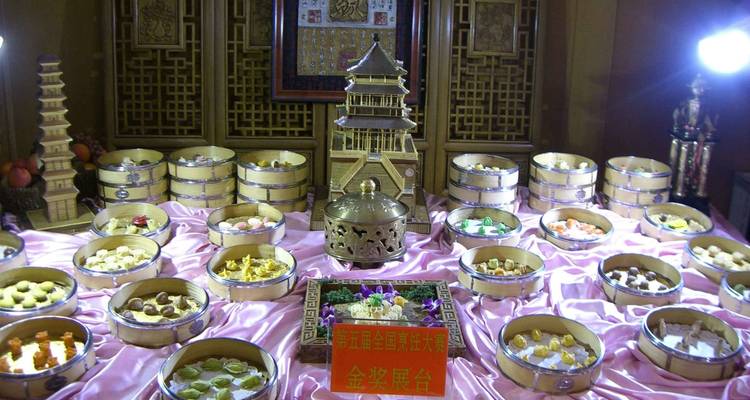 Dumplings tradicionales exhibidos en vaporeras de bambú sobre una mesa.