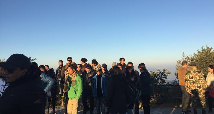 Grupo de personas al aire libre en un mirador panorámico.