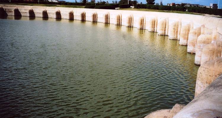 Antiguo depósito de agua con columnas al fondo.