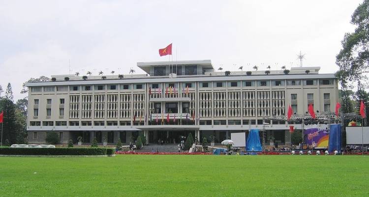 Front view of the Independence Palace with a large green field.