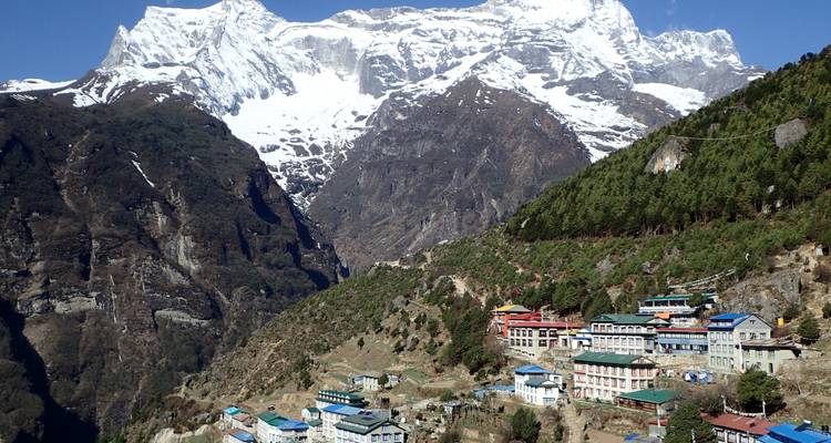 Bergdorf in Nepal mit schneebedeckten Gipfeln.