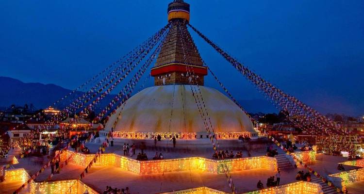Boudhanath Stupa verlicht in de avond.