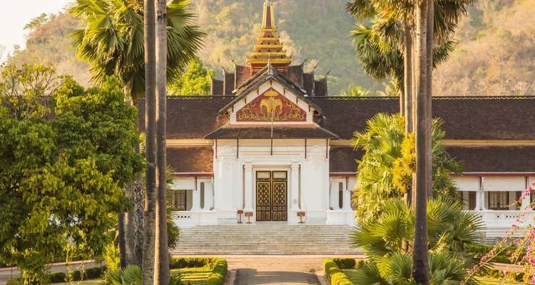 Museo del Palacio Real en Luang Prabang rodeado de palmeras.