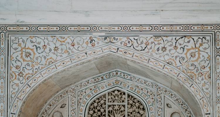 Detail of intricate floral designs on a marble building.