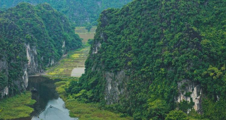Acantilados verdes y exuberantes con un río serpenteando a través de un valle frondoso.