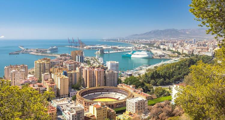Aerial view over Malaga port, bullring and Mediterranean coastline under clear skies