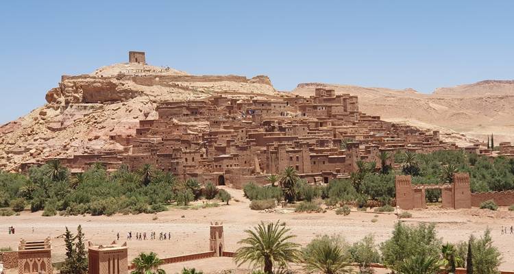 Kasbah d'Aït-Ben-Haddou au Maroc sous un ciel bleu clair.