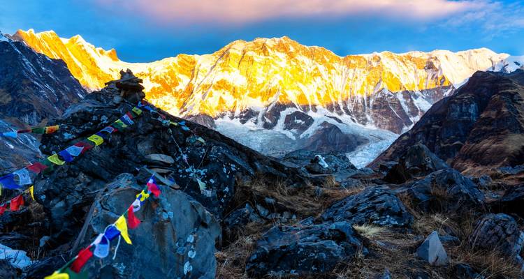 Himalaya-Berge mit Gebetsfahnen und farbenfroher Sonnenaufgangsbeleuchtung.