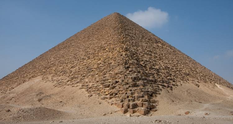 Eine Nahaufnahme einer großen Pyramide vor einem klaren blauen Himmel.
