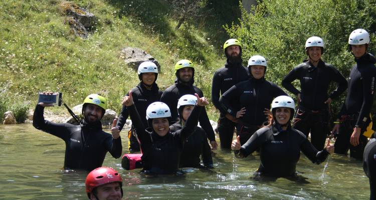 Gruppe von Menschen in Neoprenanzügen, die im Wasser stehen.