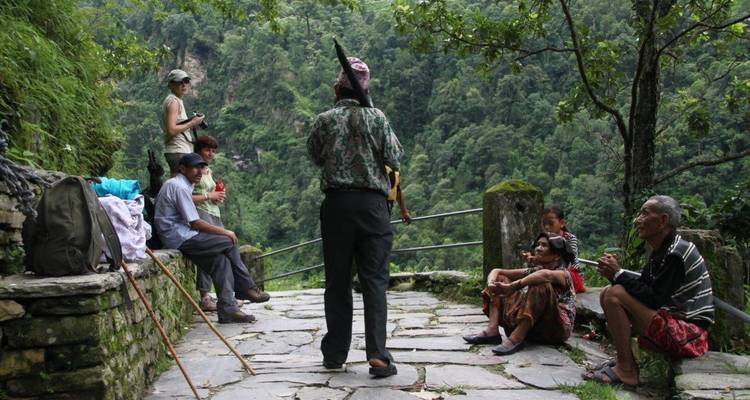 People interacting on a stone path in a rural area.