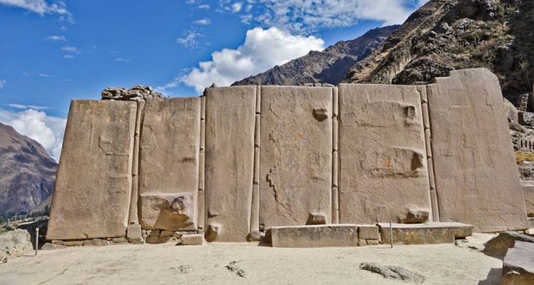 Ruinas de muro de piedra de Ollantaytambo bajo cielo azul.