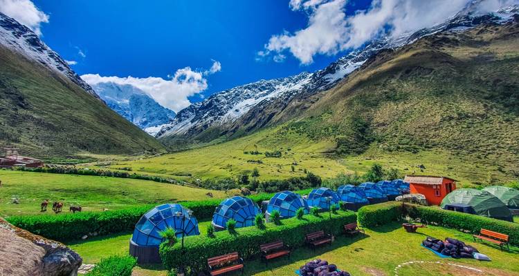 Vista de un valle con cúpulas geodésicas y montañas.