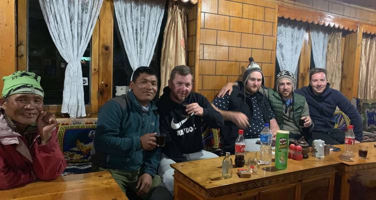 Eine Gruppe von Menschen, die Getränke in einer gemütlichen Holzhütte genießt.