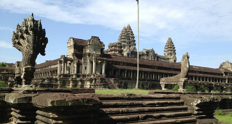 Beeindruckende antike Tempelruinen mit Naga-Statuen und klarem Himmel.