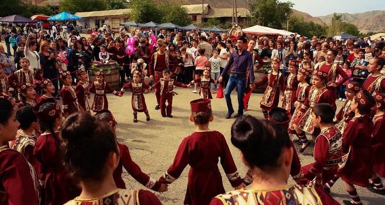 Cultural festival with people in traditional clothing dancing in a circle.