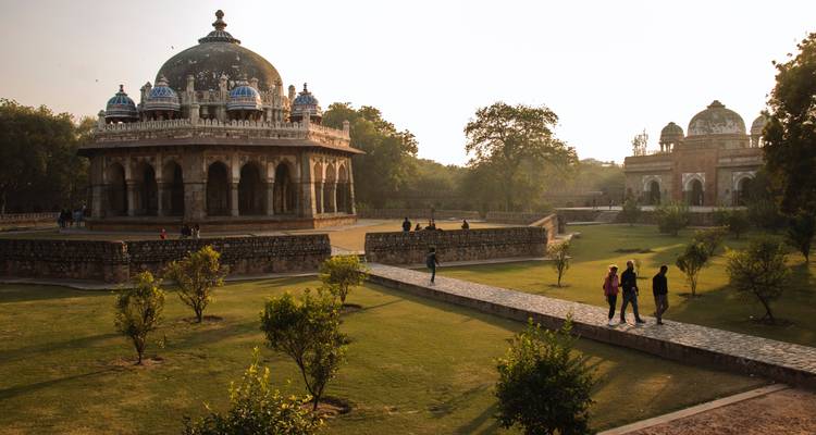 Üppiger Garten mit historischen Gräbern und Menschen, die in Neu-Delhi, Indien spazieren gehen.