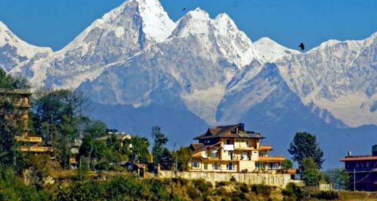 Sneeuwbedekte bergen met een huis op de voorgrond