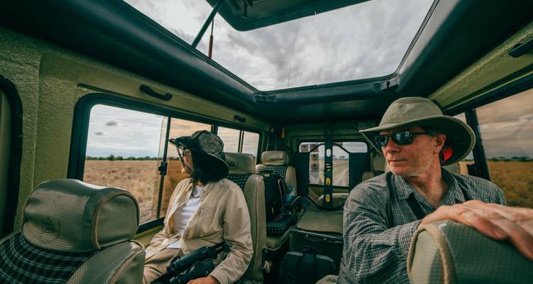 Tourists in a safari vehicle looking out at the landscape.