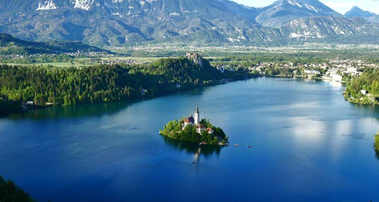 Malerische Aussicht auf den Bleder See mit der Inselkirche und den umliegenden Bergen.