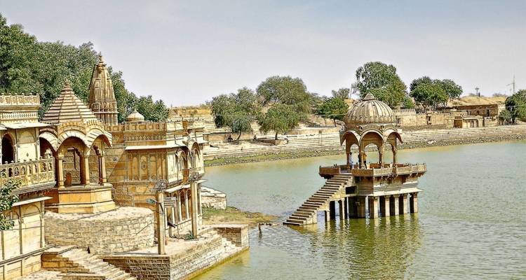 Une vue panoramique de temples au bord d'un plan d'eau à Jaisalmer.