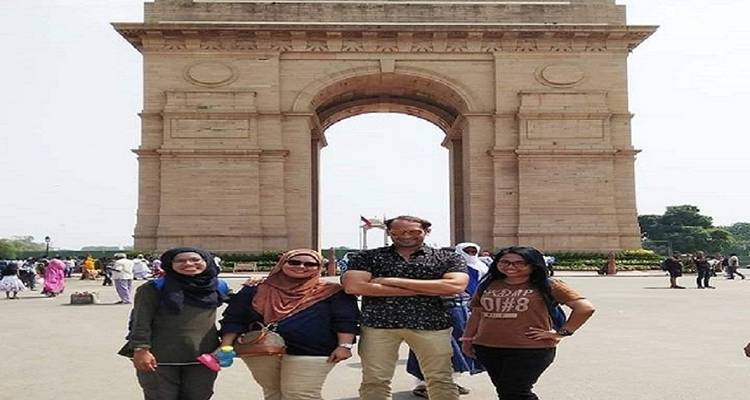 Four people standing in front of India Gate.
