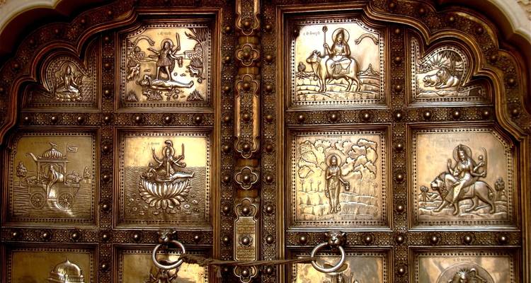 Gros plan d'une porte décorative avec des motifs religieux en relief.