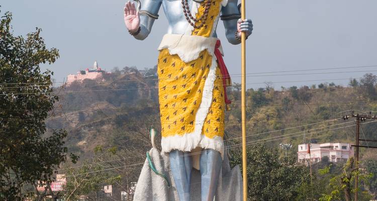 Grande statue du Seigneur Shiva avec des collines en arrière-plan.