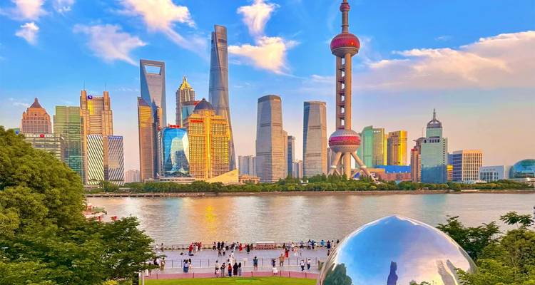 El skyline futurista de Shanghai se alza sobre el río Huangpu bajo un cielo vespertino en tonos pastel.