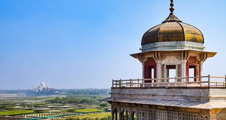 Une vue du Taj Mahal au loin, avec un pavillon au premier plan.