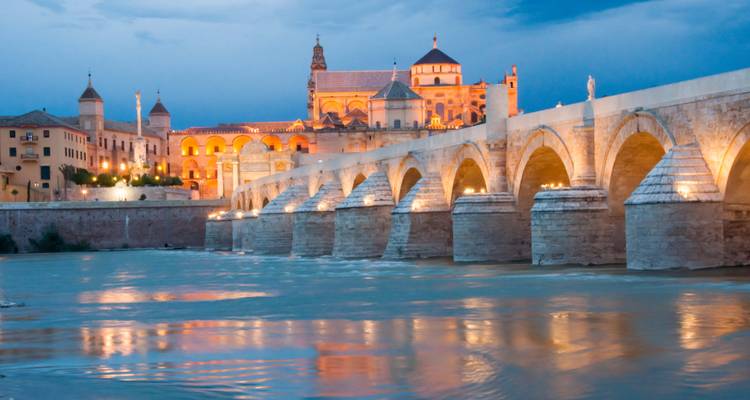 Vue crépusculaire du Pont romain de Córdoba se reflétant dans le fleuve Guadalquivir.