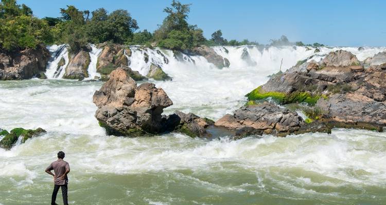 Hombre observando una gran cascada.