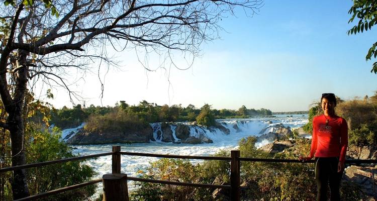 Persona en una pasarela con una cascada de fondo.