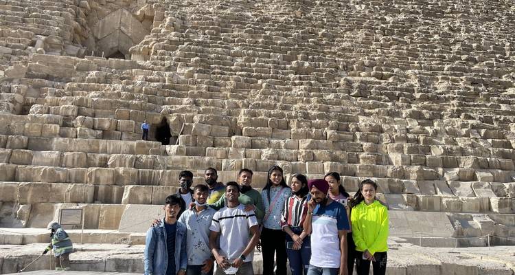 Gruppe von Touristen vor einer großen Pyramide.