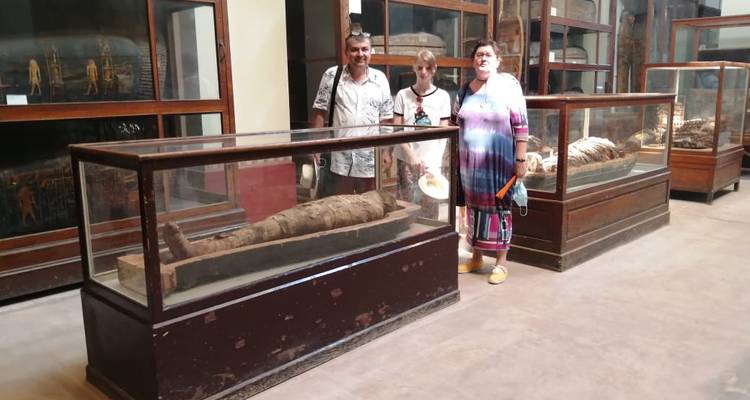 People standing next to ancient artifacts in a museum