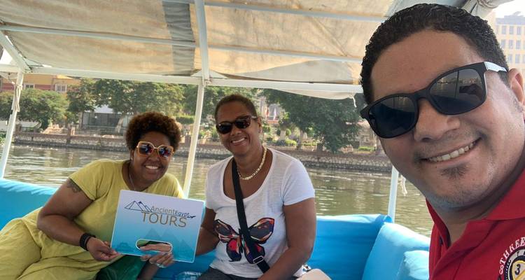 People enjoying a boat tour on a river with a tour sign