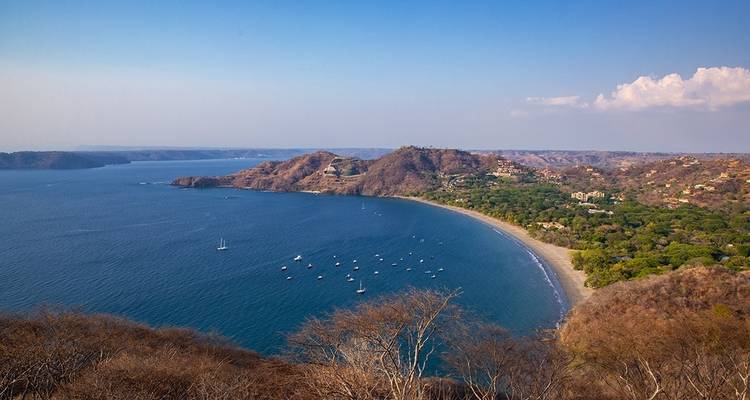 Panoramic view of a coastal bay with boats anchored.