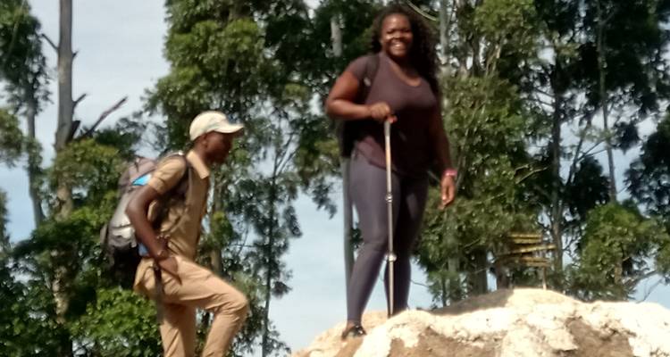 Zwei Wanderer auf einem Pfad mit Bäumen im Hintergrund.